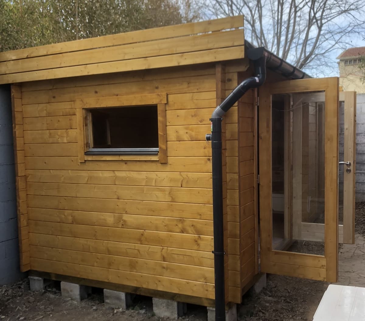 Cabanon de jardin en bois avec fenêtre et gouttière