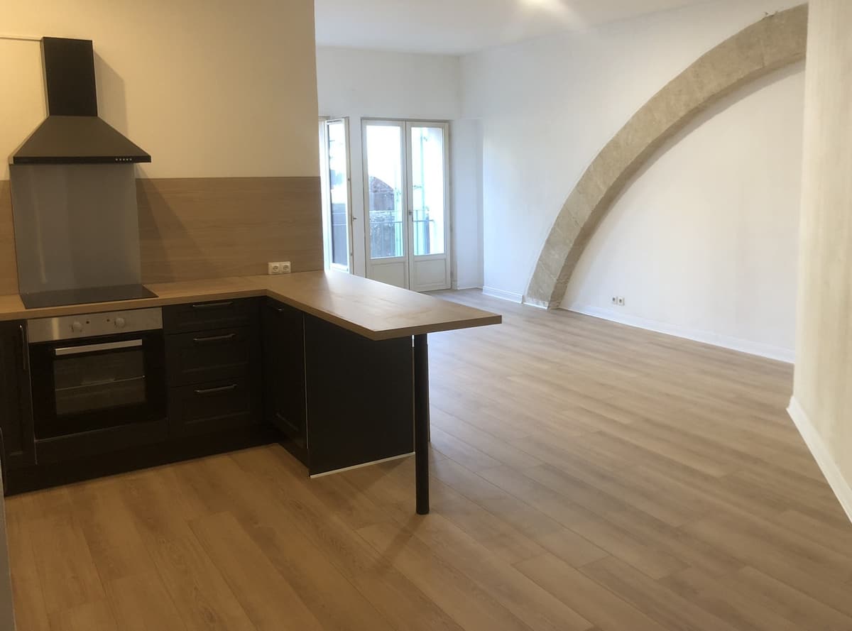 Parquet clair dans une cuisine ouverte avec arche en pierre