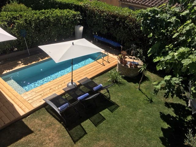 Vue plongeante sur une piscine entourée d’une terrasse bois