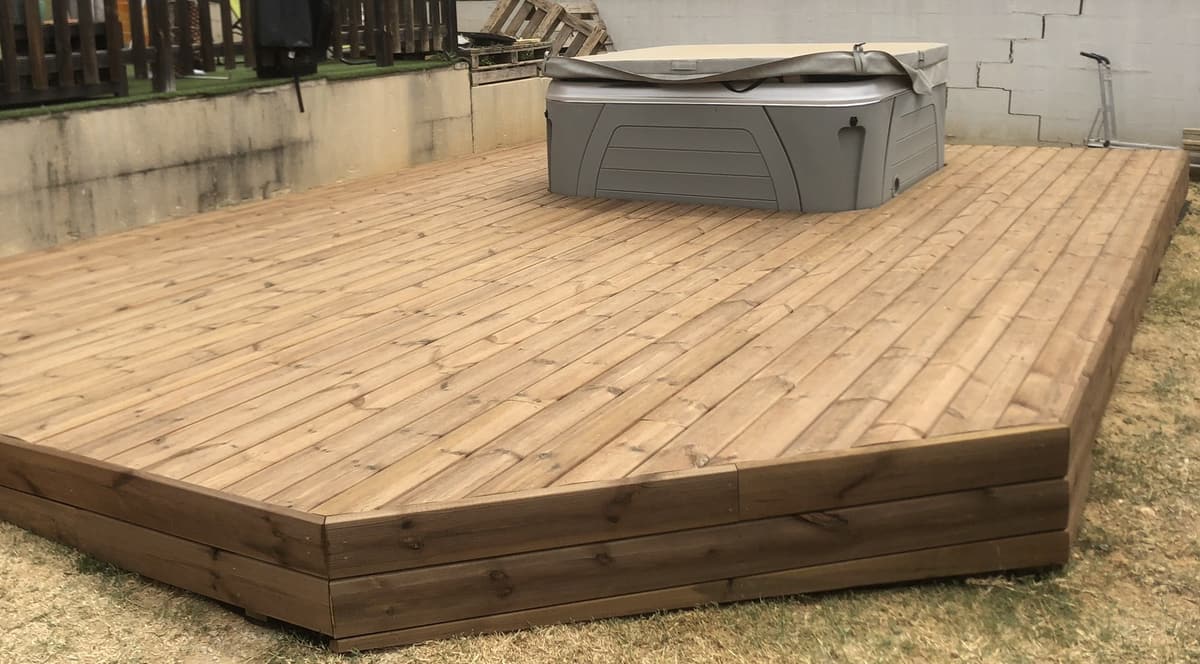 Terrasse bois surélevée accueillant un spa
