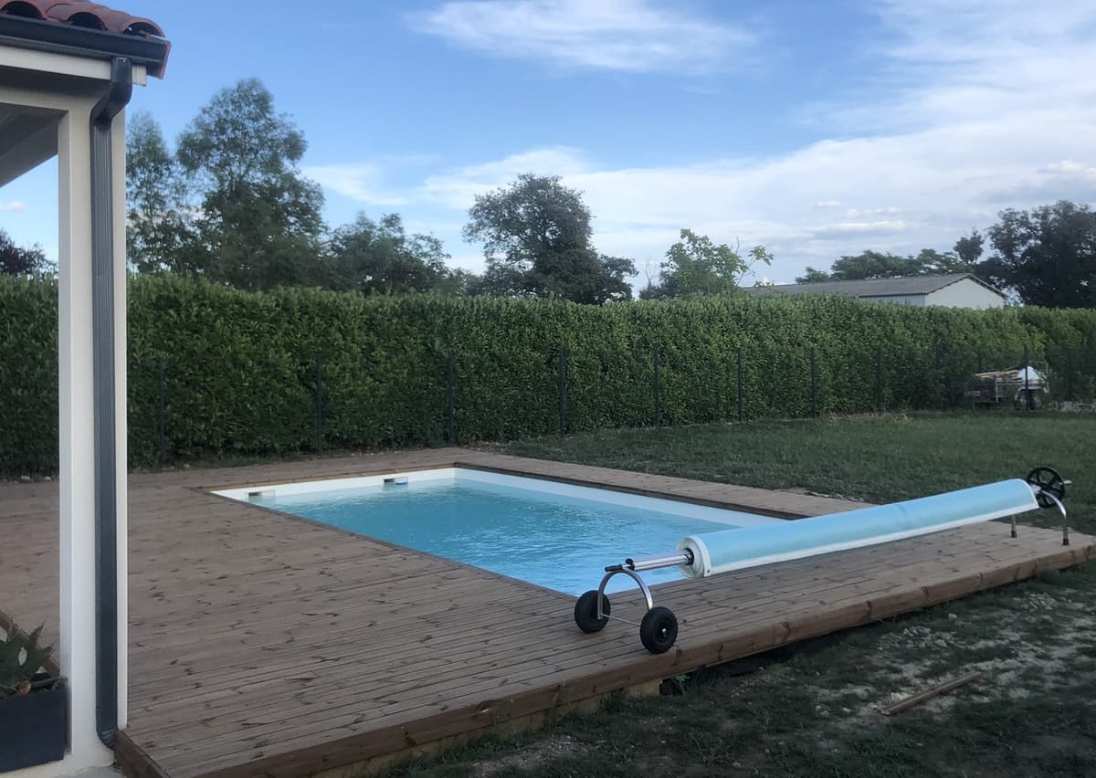 Terrasse bois autour d’une piscine avec enrouleur de bâche