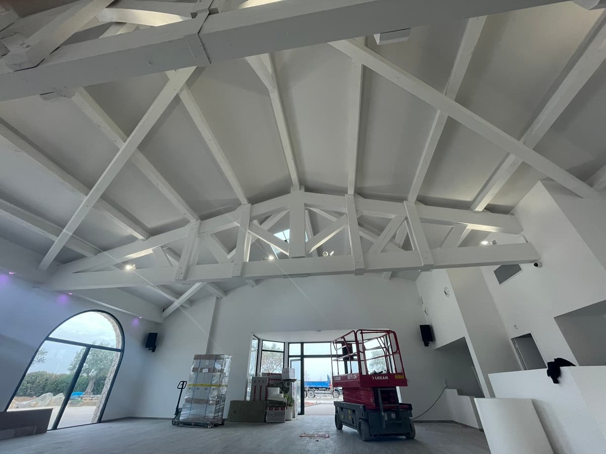 Charpente et plafond acoustique blanc dans une grande salle